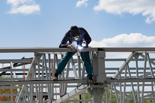 man welds at the factory on a wonderful day photo