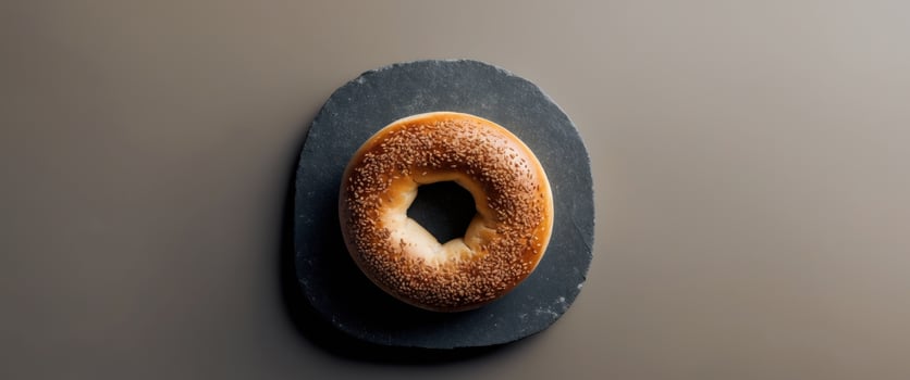 Toasted Bagel on Dark Stone Background with Empty Space for Text in Top View Perspective. photo