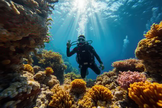 a scuba diver is standing on the reef with sunlight shining through the water photo