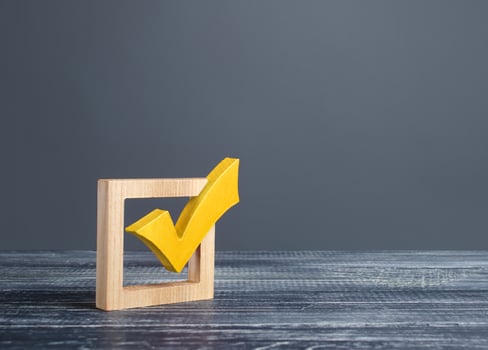 Yellow voting tick in a checkbox. Democratic institutions, vote on democratic elections, referendum. Opinion Poll. Make right choice. Confirmation, passing the test. Verification. Law implementation photo