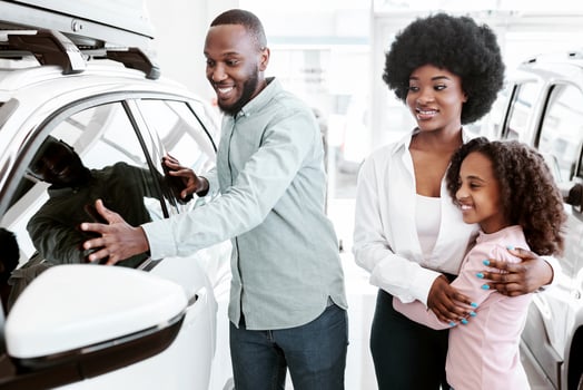 Happy black family selecting new car at auto showroom. African American customers choosing luxury automobile to rent or purchase at dealership. Vehicle local distribution concept photo