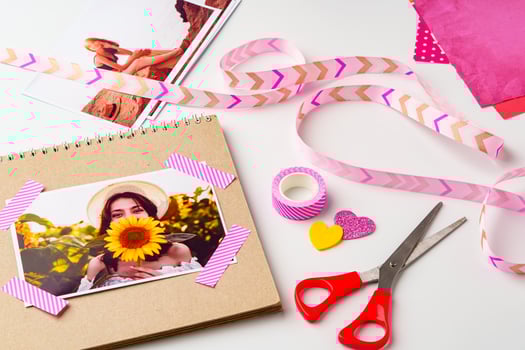 Creative scrapbook project showcasing a photo of a woman holding a sunflower with colorful decorations and crafting supplies
