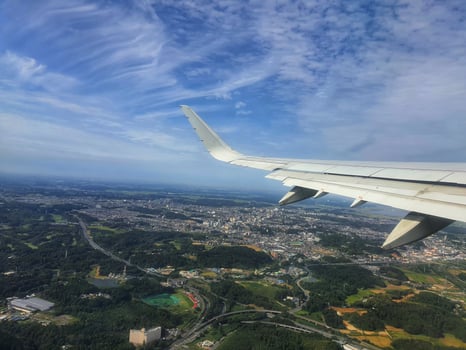 Airplane Wing View Serene Cityscape Lush Greenery Blue Sky photo