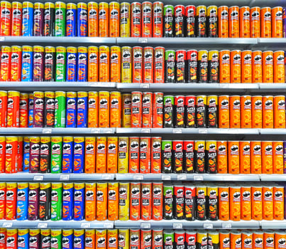 Madinah, Saudi Arabia on 28 February 2024. Colorful Potato Chip Cans Grocery Store Shelf Display photo