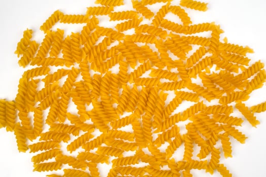 Fusilli paste spiral shape on a white background. Background of pasta. Top view. Selective focus. photo