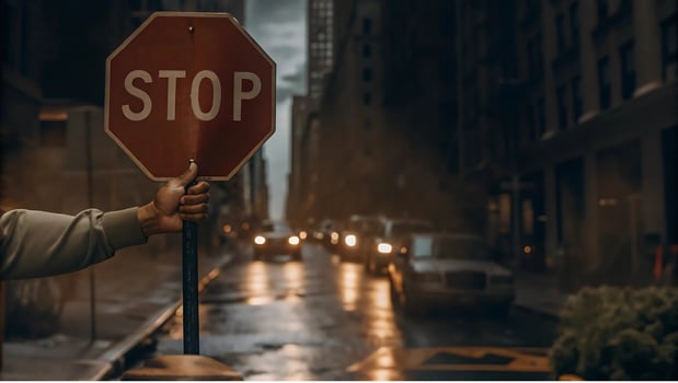 Stop sign held during nighttime in a rainy city, traffic safety at night, urban road caution, wet street transportation, nighttime cityscape, road safety and traffic regulation, cautionary visuals photo