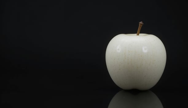 A Single White Apple Against a Black Background. A Study in Contrast and Minimalism photo