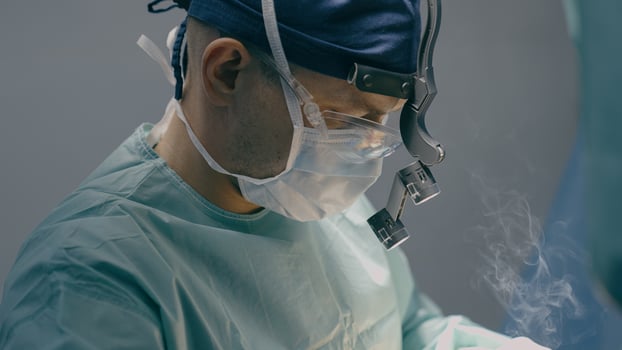 Close up doctor man physician practitioner surgeon medic in protective medical mask perform surgical operation microscope plastic surgery cautery modern medical treatment medicine hospital health care photo