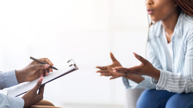 Psychologist providing professional psychological help to black female patient at clinic, closeup. Counselor giving consultation to young African American woman, banner design photo