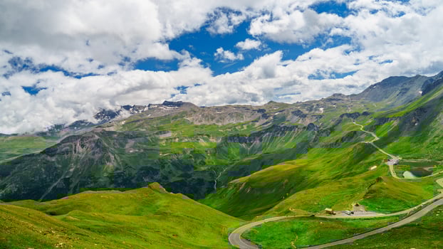 The Grossglockner High Alpine Road in Kaprun, Austria, offers breathtaking views of the Alps. This scenic drive winds through green valleys and past towering mountains. photo