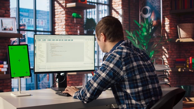 Software engineer at computer coding, creating software using isolated screen tablet. IT specialist in home office working with code editor, building applications using PC and mockup device, camera A photo