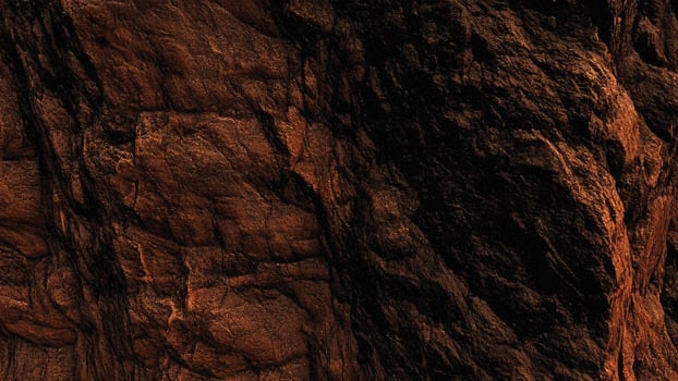 Dark brown rock face with deep crevices and rugged stone formations, representing natural erosion and mineral-rich patterns perfect for architectural and geological background designs. photo