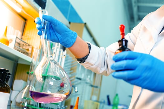 Researcher conducts chemical experiment with flask and reagent in laboratory setting photo