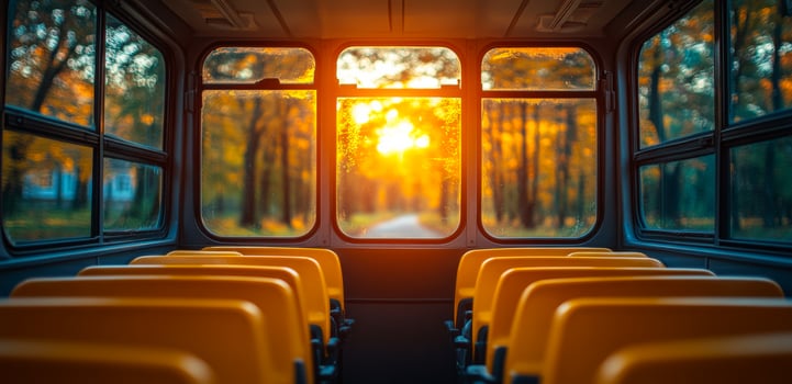 Warm sunset viewed from empty bus seats. Bright orange sunset shines through bus windows, illuminating empty yellow seats in a tranquil forest setting. photo