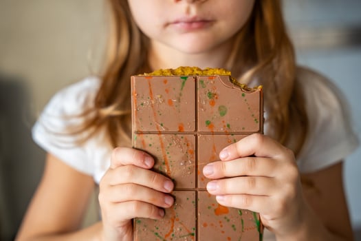 Dubai chocolate with pistachio paste and kataifi dough in hands of little girl. Confectionery handmade sweets at home in the kitchen. High quality photo