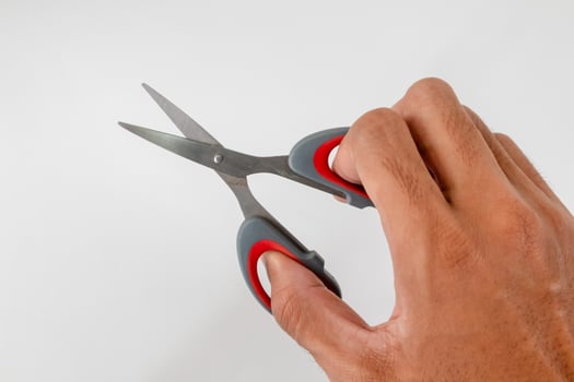 A man's hand holding a pair of scissors photo