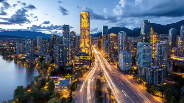The city of vancouver is seen at dusk with a highway and water photo