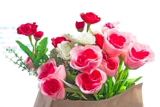 Bouquet of pink, red and white artificial roses with green leaves on a white background photo