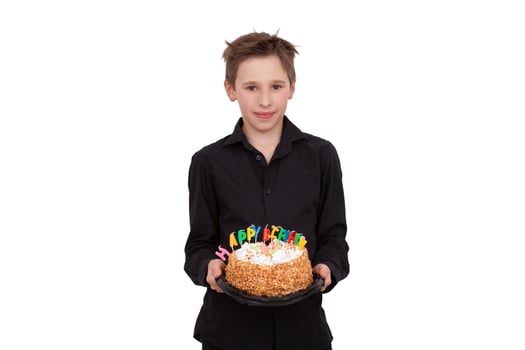 A teenage boy holds a birthday cake on a white background photo