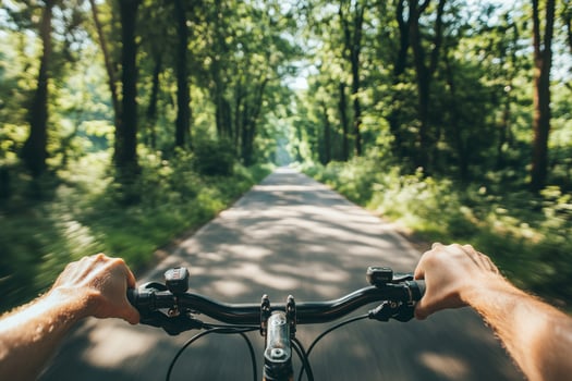 Cyclist riding through a scenic forest road photo