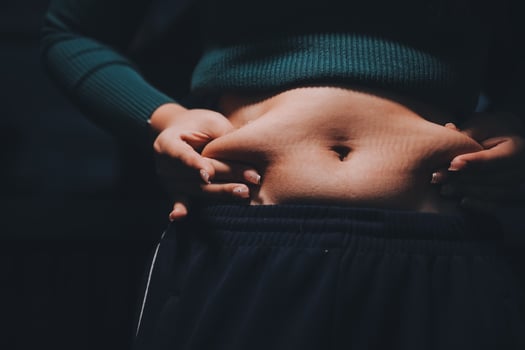 A woman with her stomach showing off her belly photo