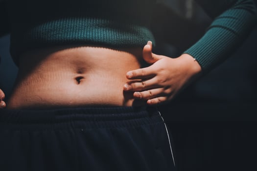 A woman with her hands on her stomach photo