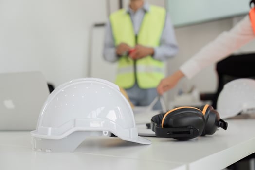 Construction team preparing safety equipment for site meeting with helmets and ear protection photo