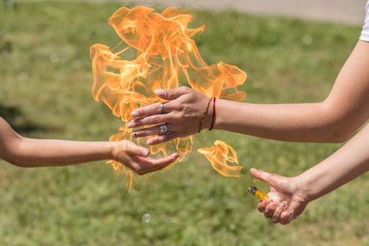 Street performer holding fire in hand outdoors photo