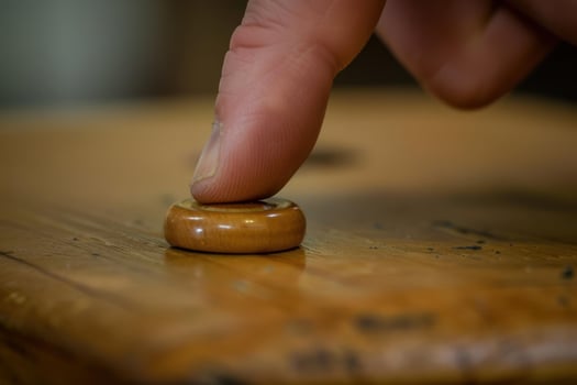 Carpenter pushing small wooden dowel on wooden table photo