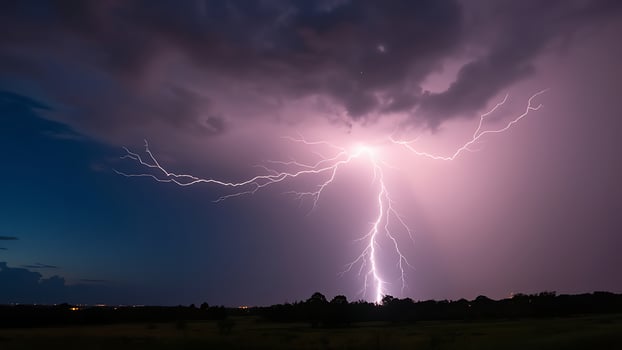 At night, lightning flashes across the sky photo