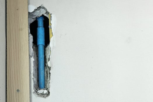 Blue PVC Water Pipe Embedded in a Concrete Wall During Construction. photo