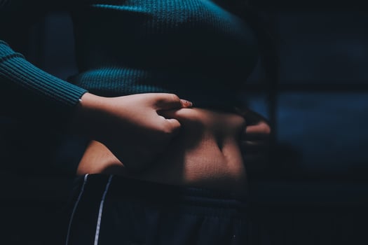 A woman with her hands on her stomach photo