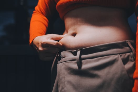 A woman with her stomach showing off her pants photo