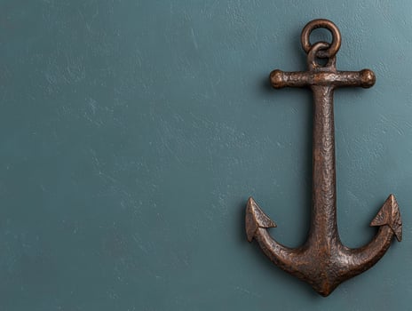 Rustic bronze anchor on a dark teal background photo