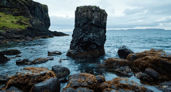 Dark columnar basalt rock formation in the ocean photo