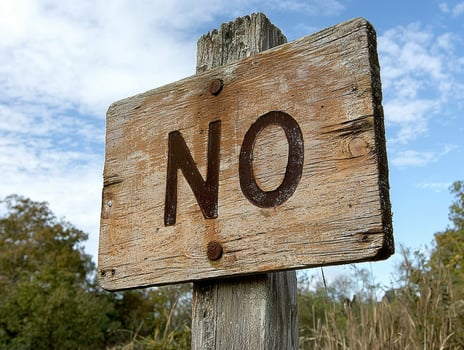 Close up of a weathered wooden sign with the word NO photo