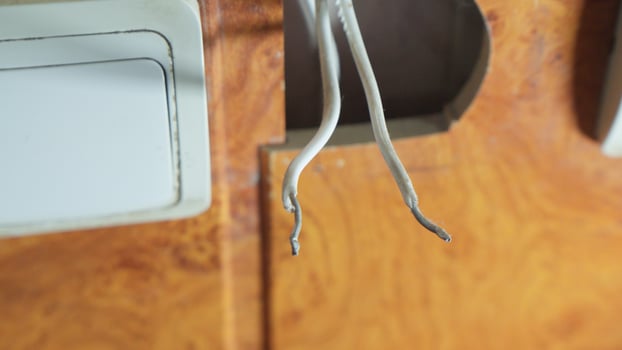 Damaged electrical wires with exposed sections, requiring immediate repair. photo