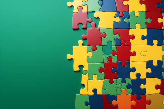 Colorful jigsaw puzzle pieces forming a big part of the solution on green background photo