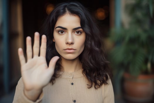 Serious young woman making stop gesture with hand in front of face photo