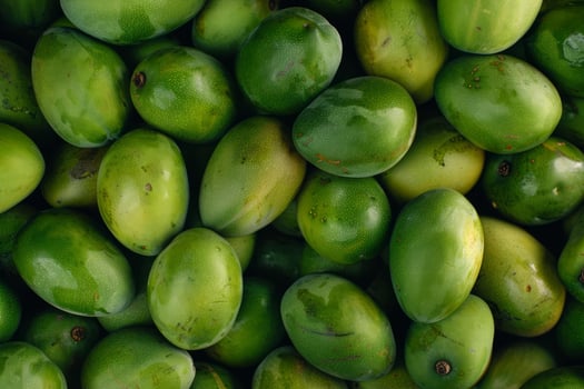 Fresh green mangoes filling the frame, creating vibrant tropical pattern photo