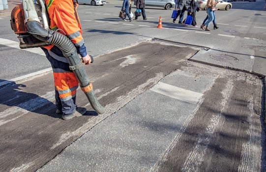 Street maintenance crew working on pavement repair during a bright sunny day photo