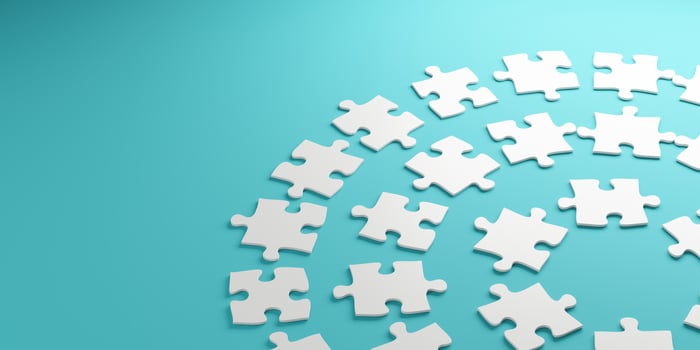White puzzle pieces arranged in a circular pattern on a blue background. photo