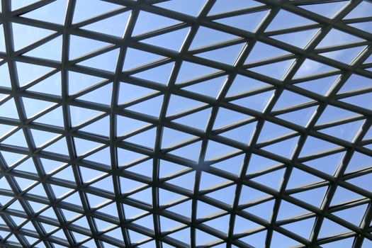A modern architectural design featuring a triangular glass roof, maximizing natural light penetration into the building while adding an aesthetic and eco friendly element to the structure. photo