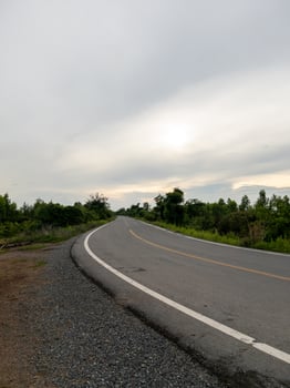Curved Asphalt Road Along an Irrigation Canal in a Rural Landscape. photo