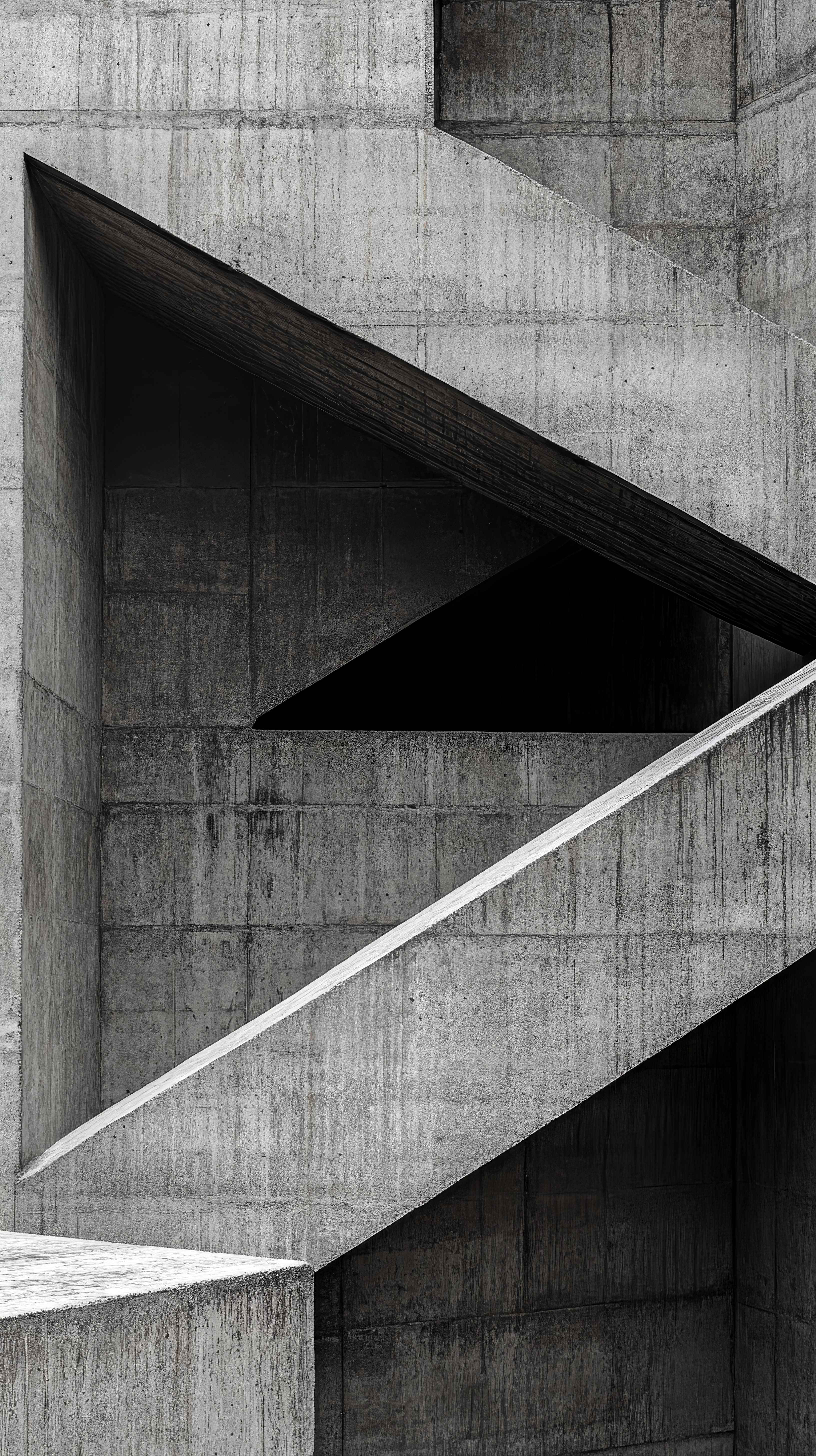 An abstract background features a textured concrete surface with sharp geometric shapes and angles. The interplay of light and shadows enhances the modern aesthetic photo