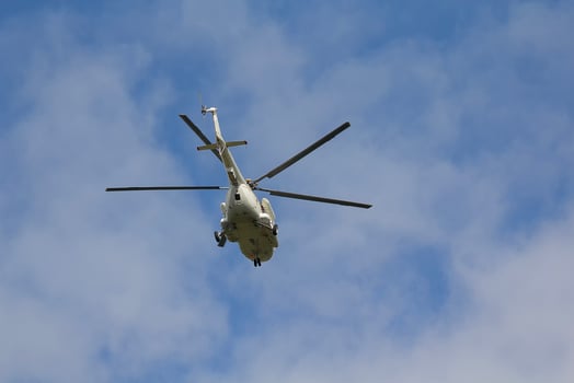 Helicopter flies against a blue sky background photo