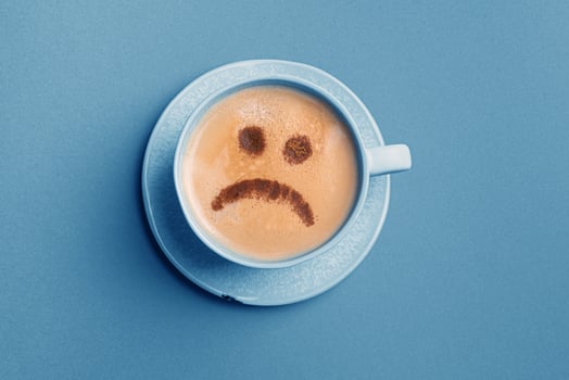 Upset face on coffee foam. Blue Monday. photo