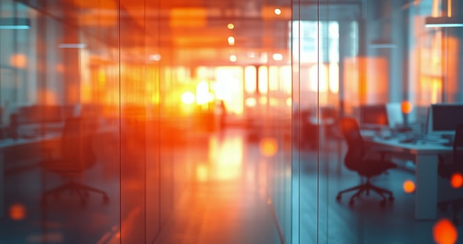 Bright sunset light filters through glass walls of a modern office space in the evening photo