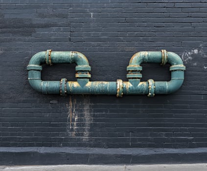Leak pipe on a dark wall with rusted fixtures photo