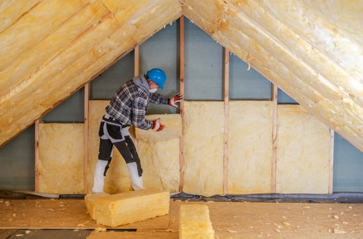 Worker Installs Mineral Wool Insulation in Residential Attic During Daylight Hours photo